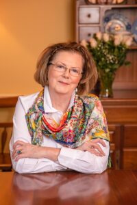 A woman with glasses and a colorful scarf