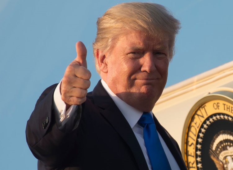 A man in suit and tie giving the thumbs up.