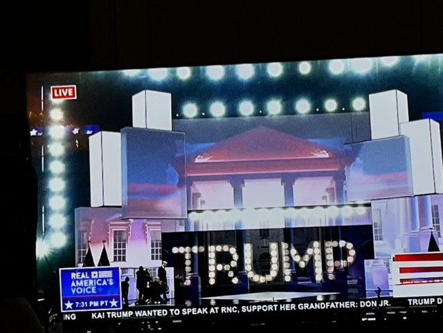 A large screen with the word trump written in lights.