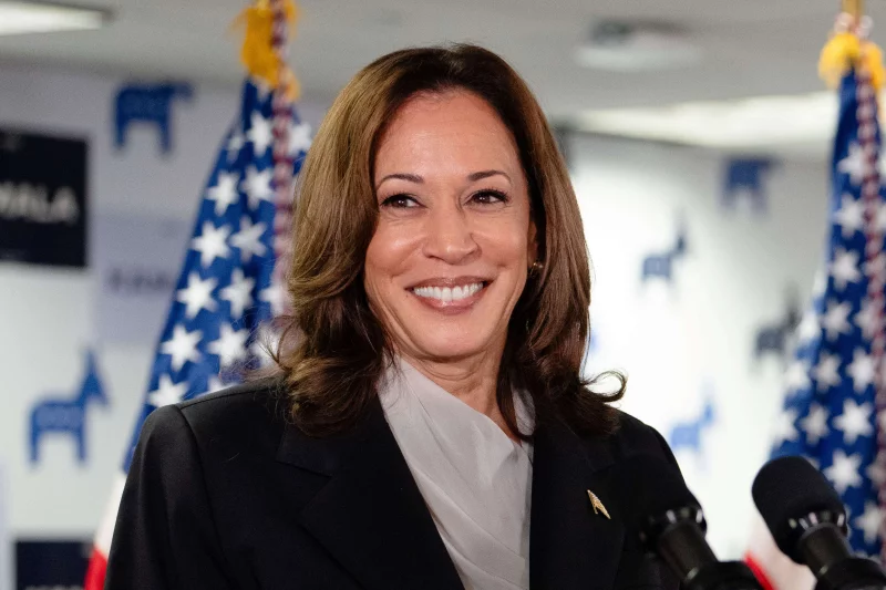 A woman in a suit and tie smiling for the camera.